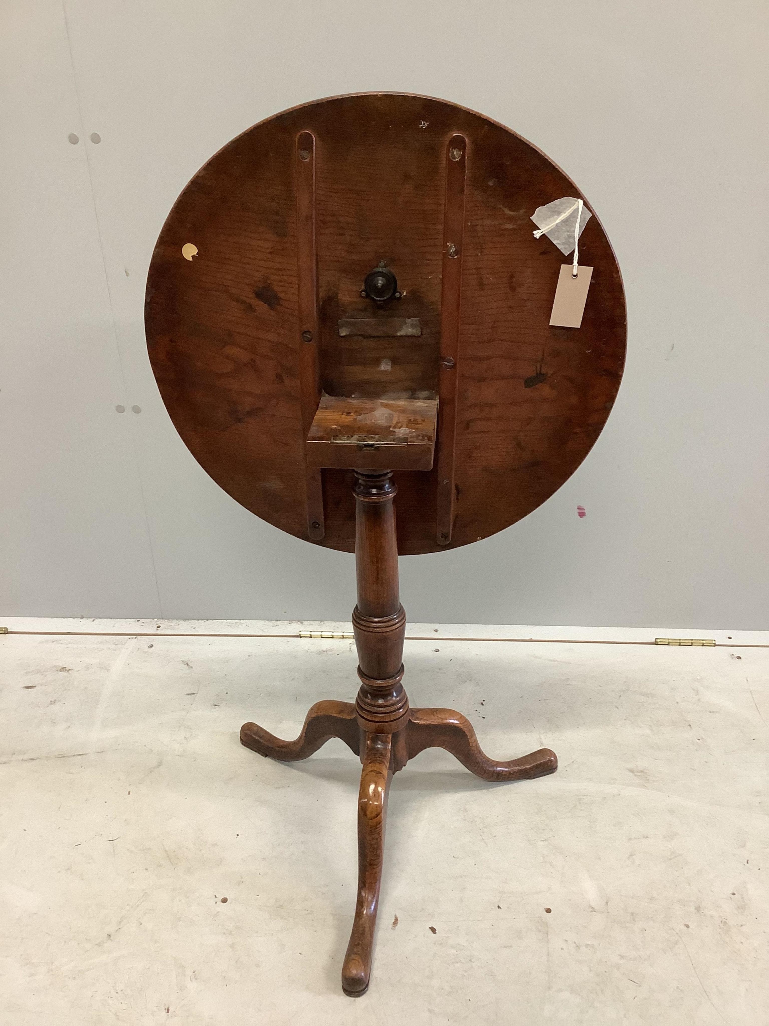 A George III circular oak tripod table, diameter 58cm, height 66cm. Condition - fair to good